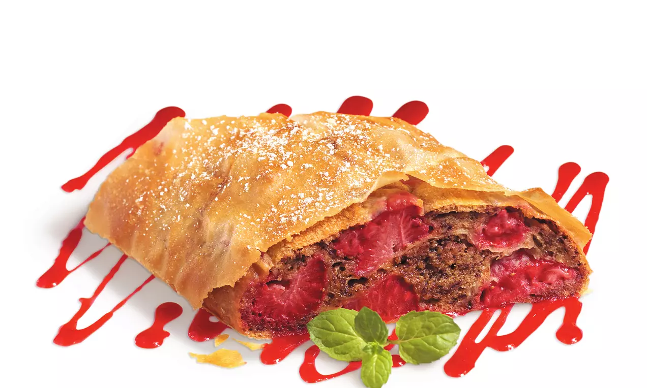 Goldbrauner, länglicher Schokostrudel mit knusprigem Teig und erdbeerroter Füllung, bestäubt mit Puderzucker auf Holzbrett mit frischen Erdbeeren